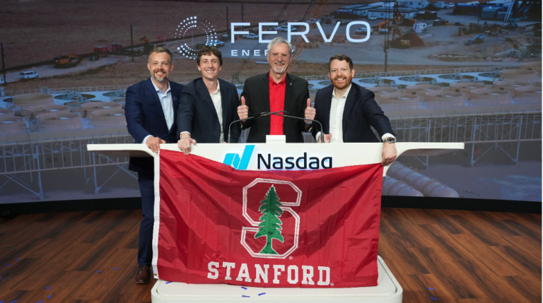 Four men in suits pose behind a Nasdaq podium, holding a red Stanford banner with the Stanford tree logo on a stage backdrop that includes 'FERV0' energy branding.